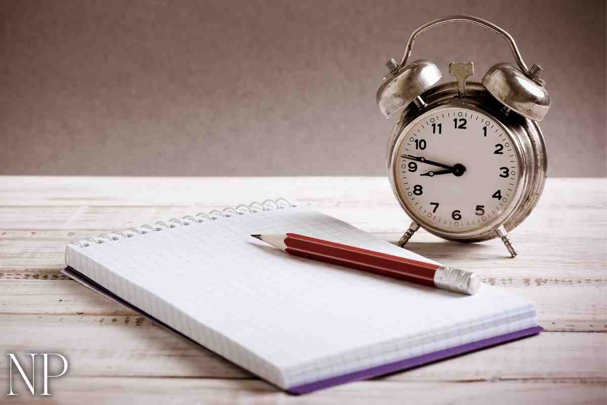 An alarm clock and a pad and pencil